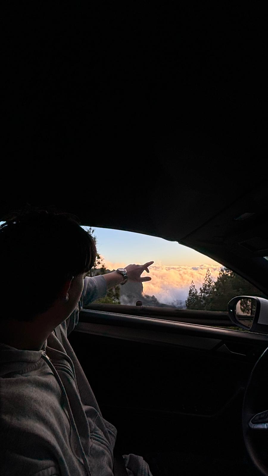 Gabriel zeigt aus dem Auto auf Wolken bei Sonnenuntergang — Vision für ein neues Leben